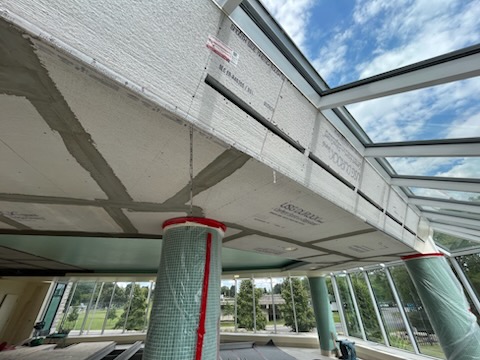 Retombée de plafond en construction le long d’un mur-rideau vitré