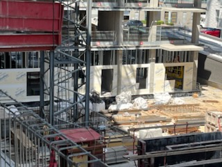 Façade d’un bâtiment en chantier avec colombages d’acier et panneaux extérieurs