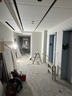 Corridor institutionnel avec plafond suspendu et cloisons de gypse en cours de finition